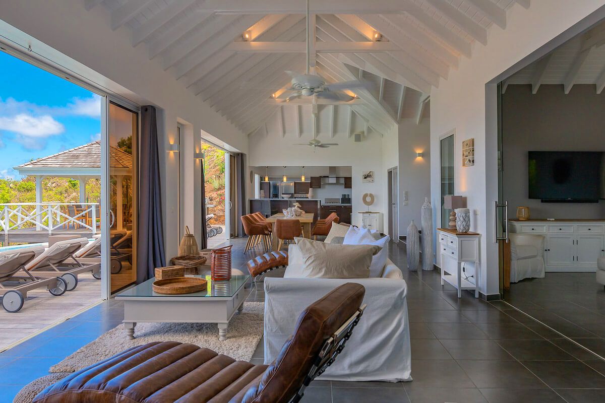 Large sliding glass doors open to the outdoor pool deck