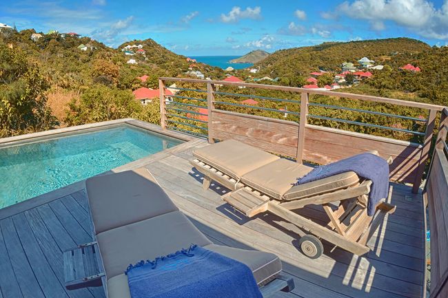 Lounge on the deck at Ti Lama with ocean views in the distance