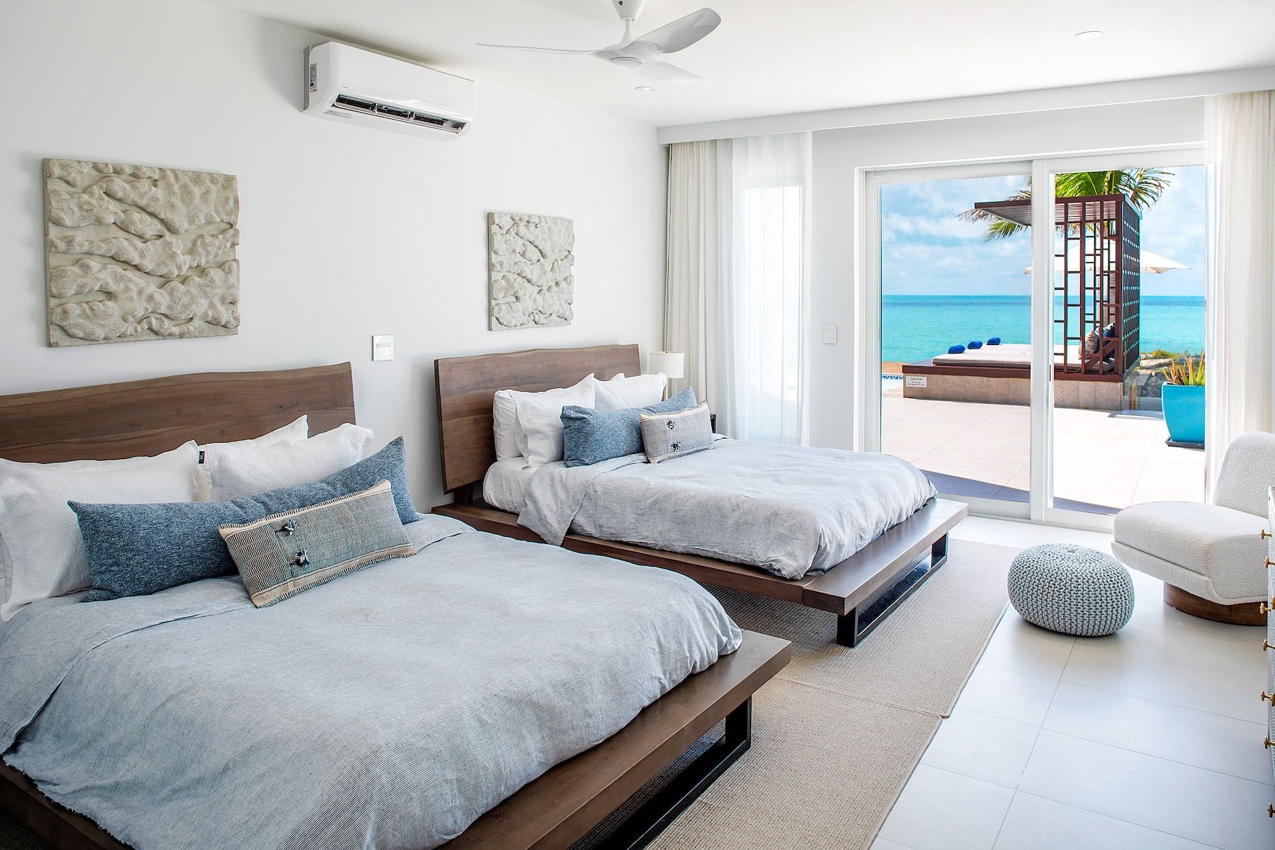 The first upper level bedroom has two queen beds with glass doors open to the patio