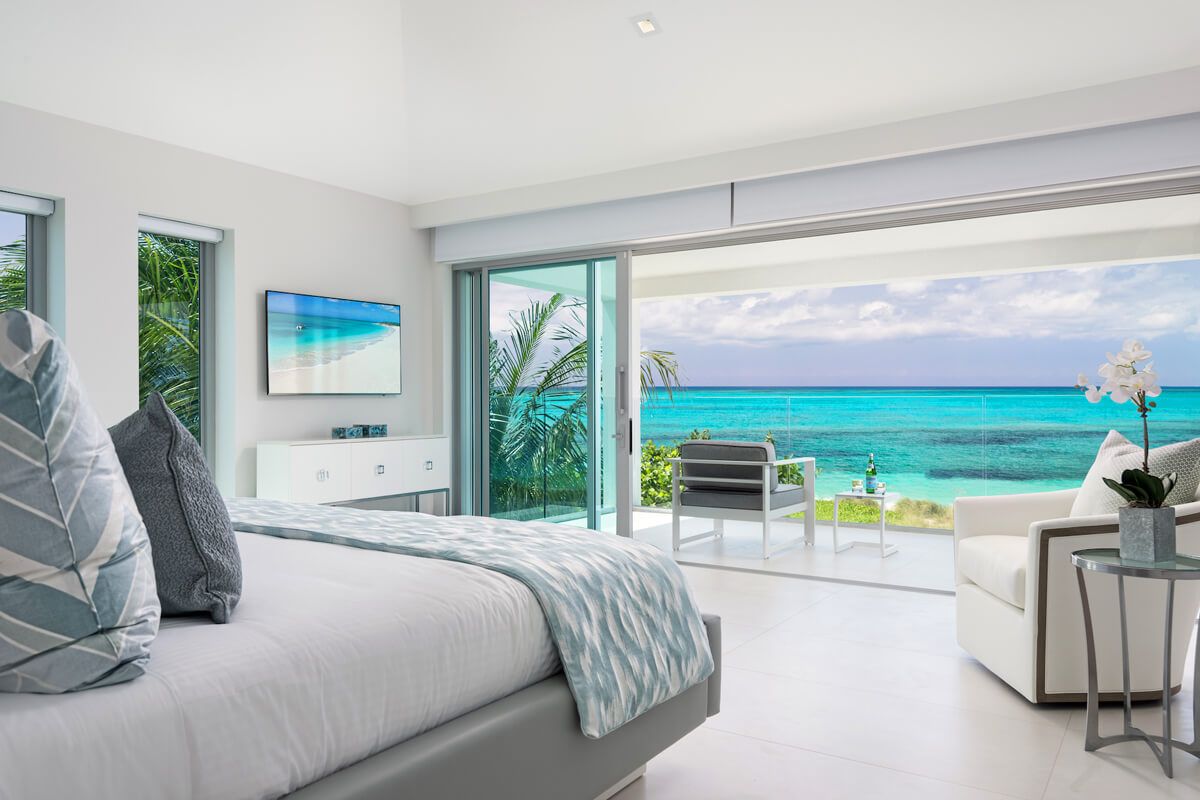 King bedroom with ocean views and patio access