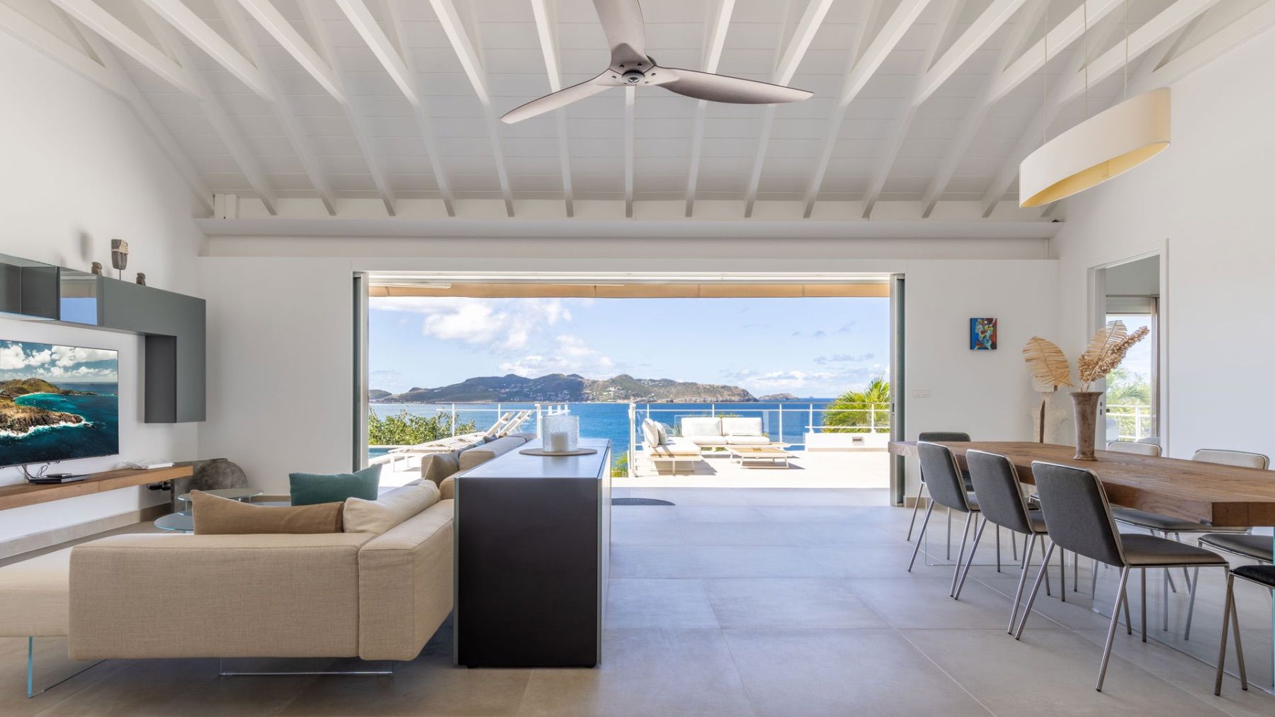 Open living area with views out to the pool and sea