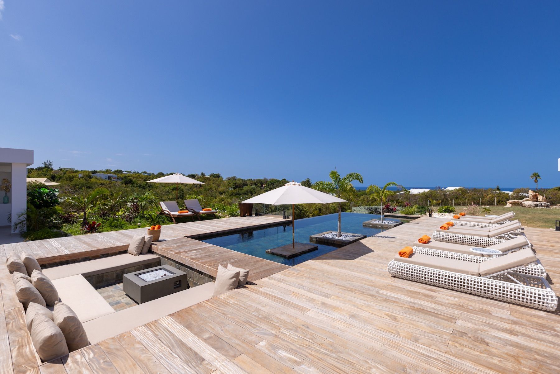 Swimming pool with adjacent loungers and fire pit
