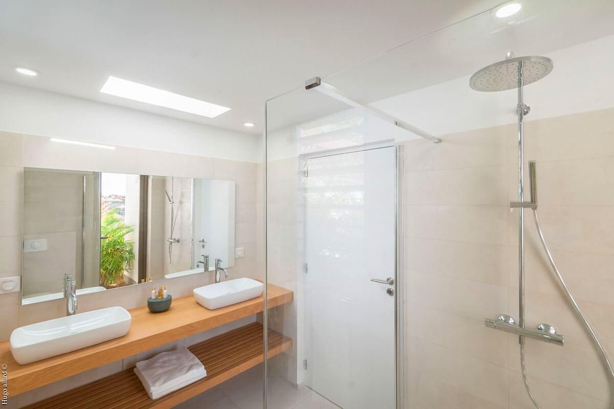 Bathroom with dual vanities and a rain head shower