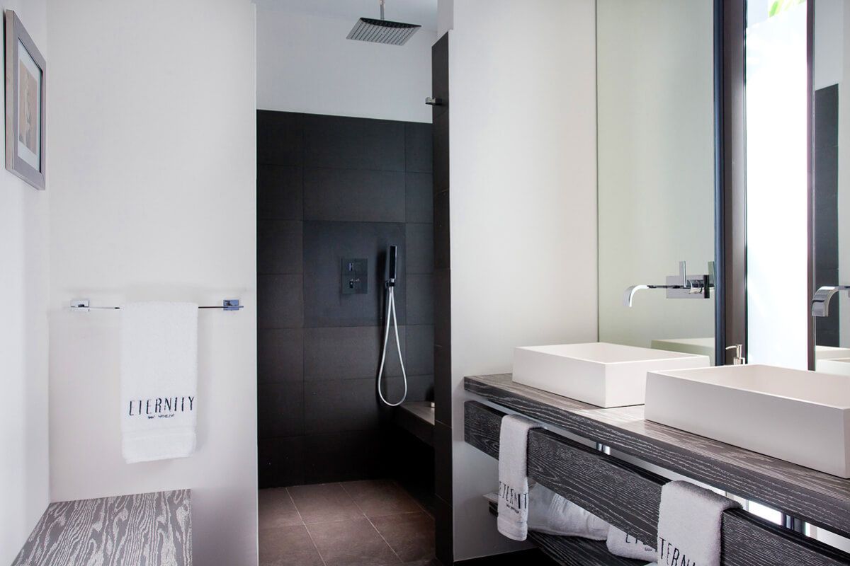 A double vanity en suite bathroom with a shower