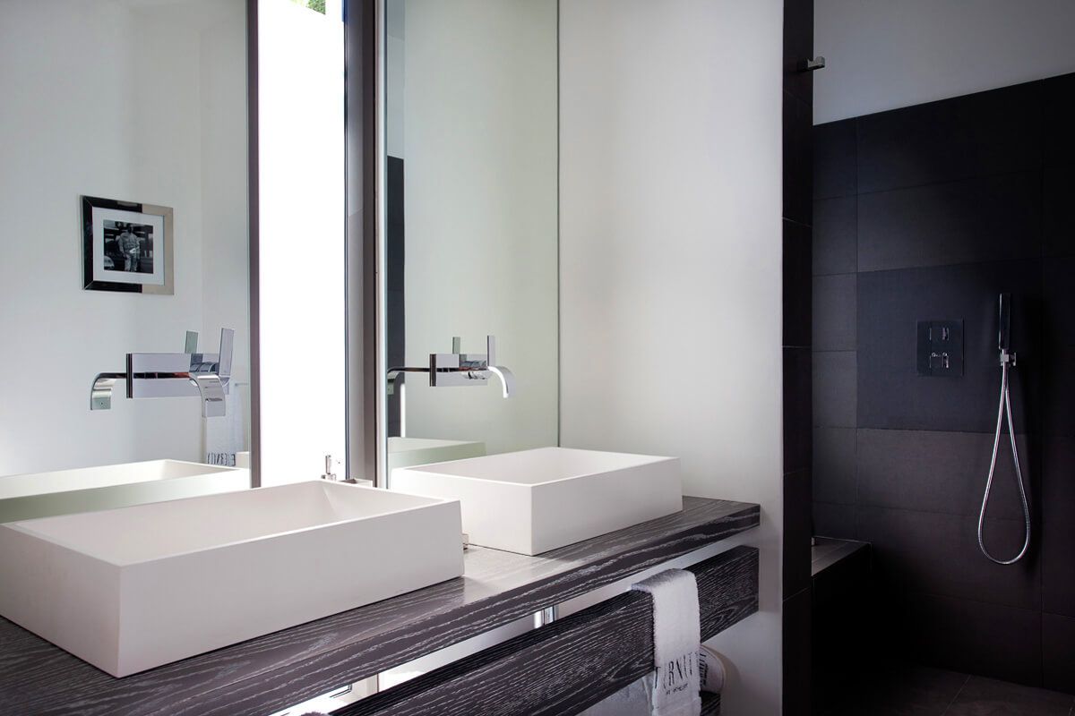 A double vanity en suite bathroom with a shower