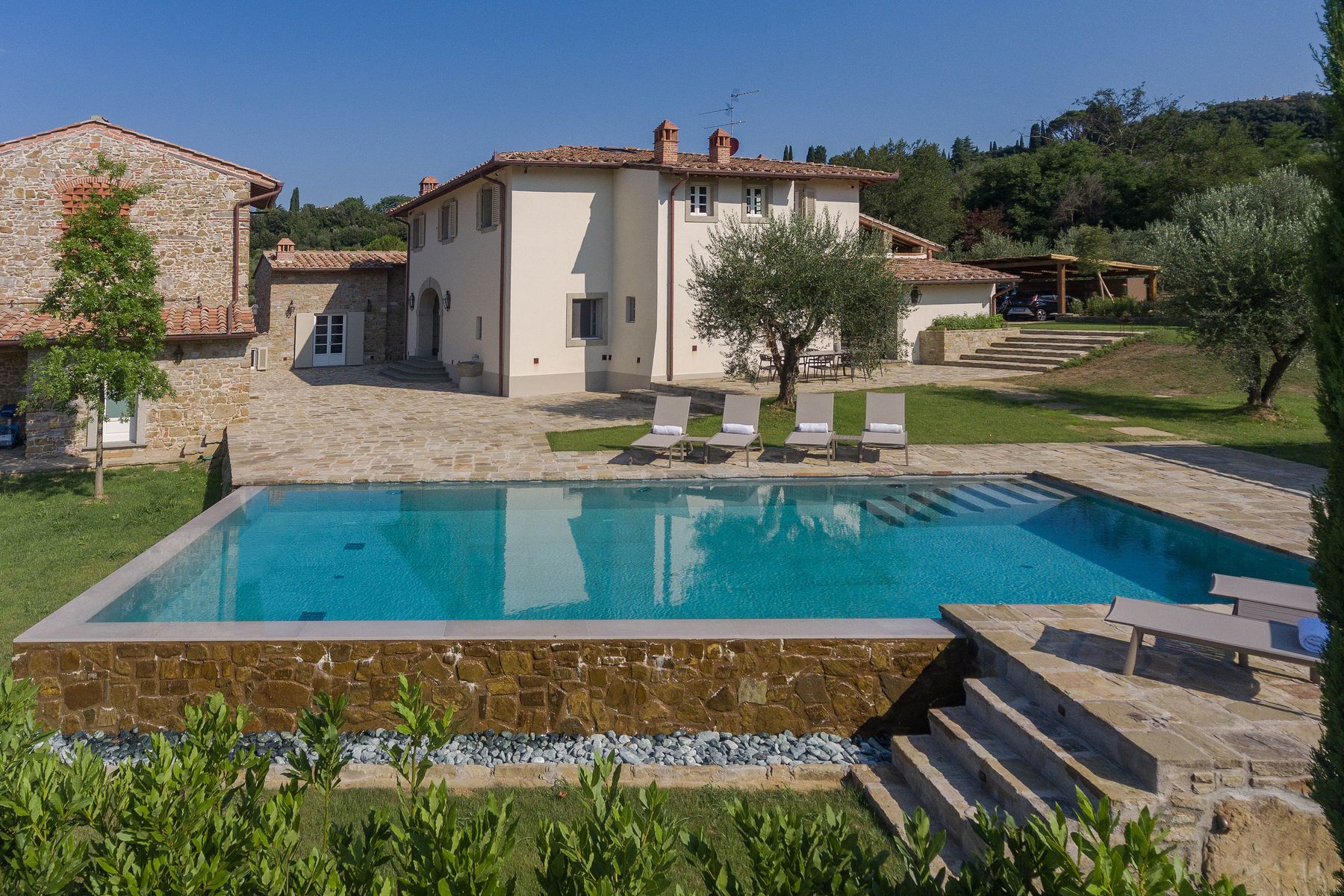 Swimming pool with adjacent loungers