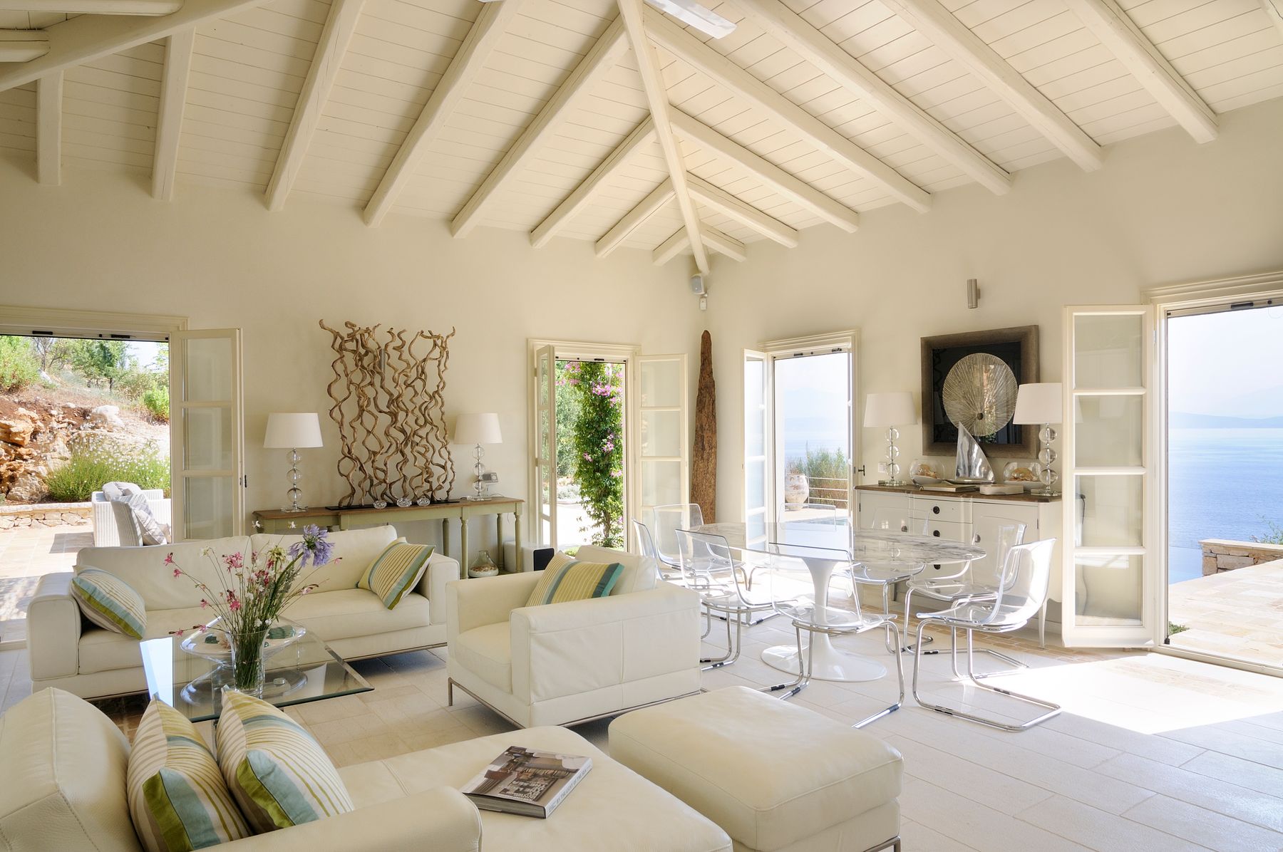 Modern open-plan living with neutral colors and large doors that lead directly to the terrace blurring the lines between the interior and outdoor areas.