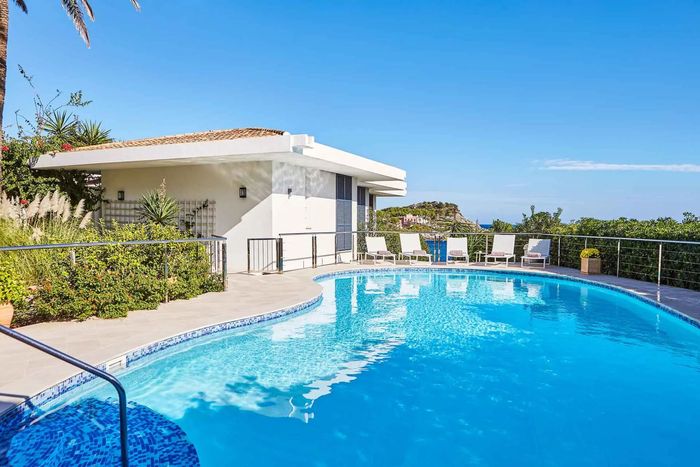 Private swimming pool flanked by sun loungers. 