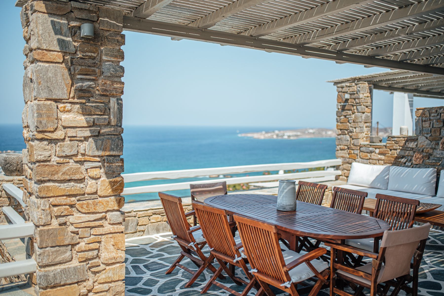 Look out to the sea from the charming pergola-shaded dining area, with a table seating eight guests.