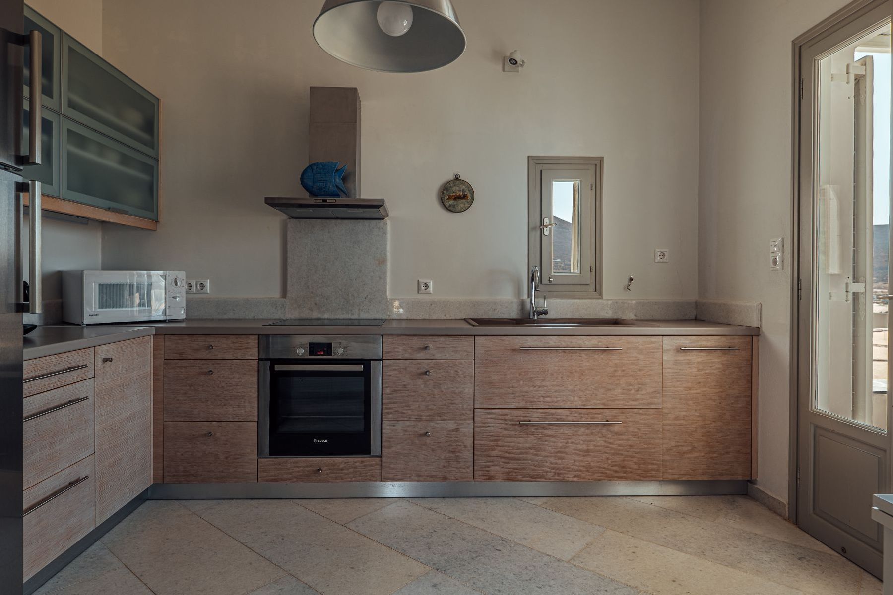 Modern fully-equipped kitchen with induction hob and access to the terrace. 