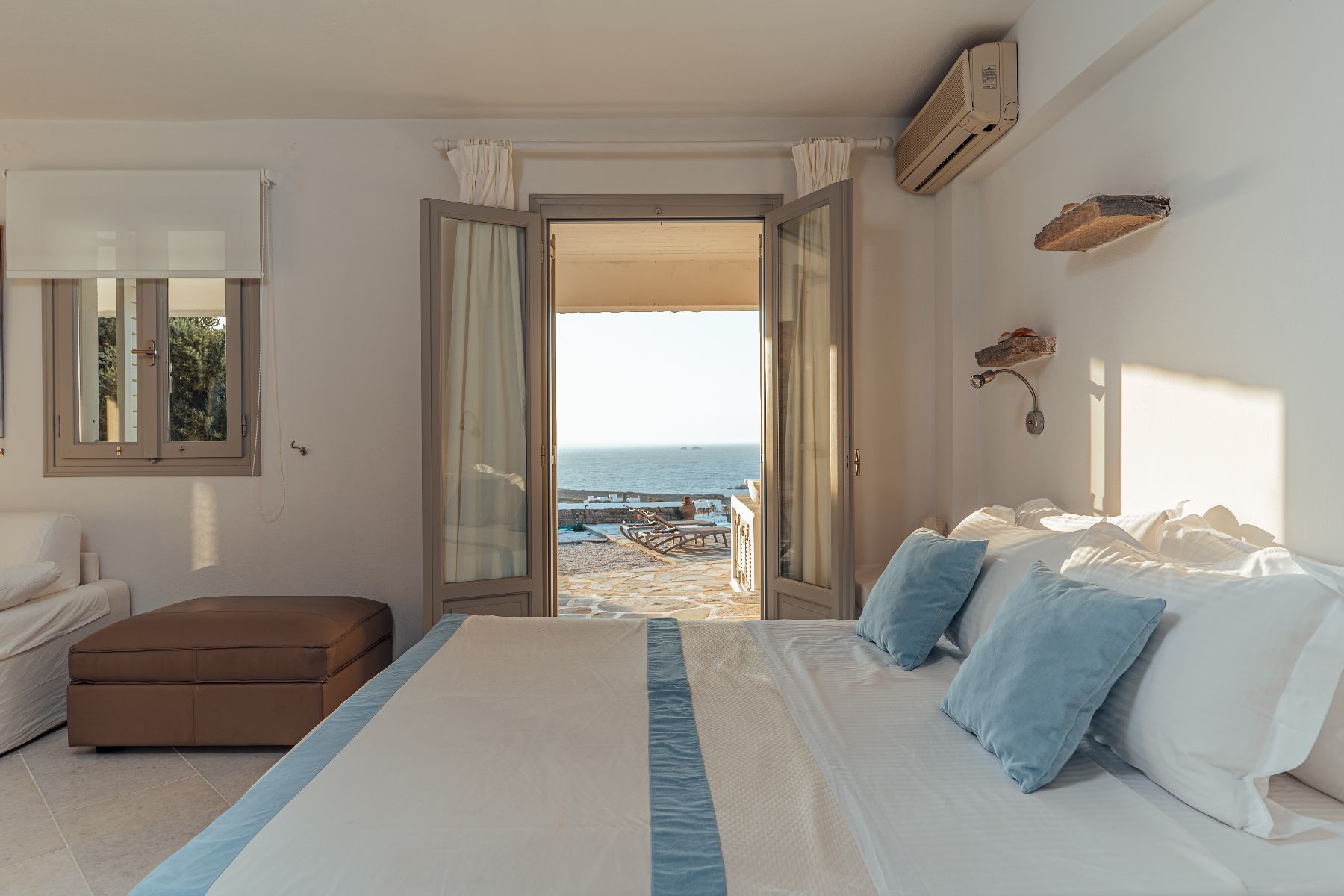 Double ensuite bedroom with access to a private terrace and pool area featuring sea views.
