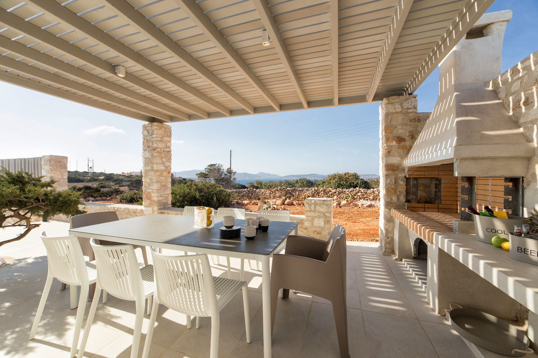 Shaded-pergola outdoor dining space for seating up to eight guests, and wood-fire BBQ area. 