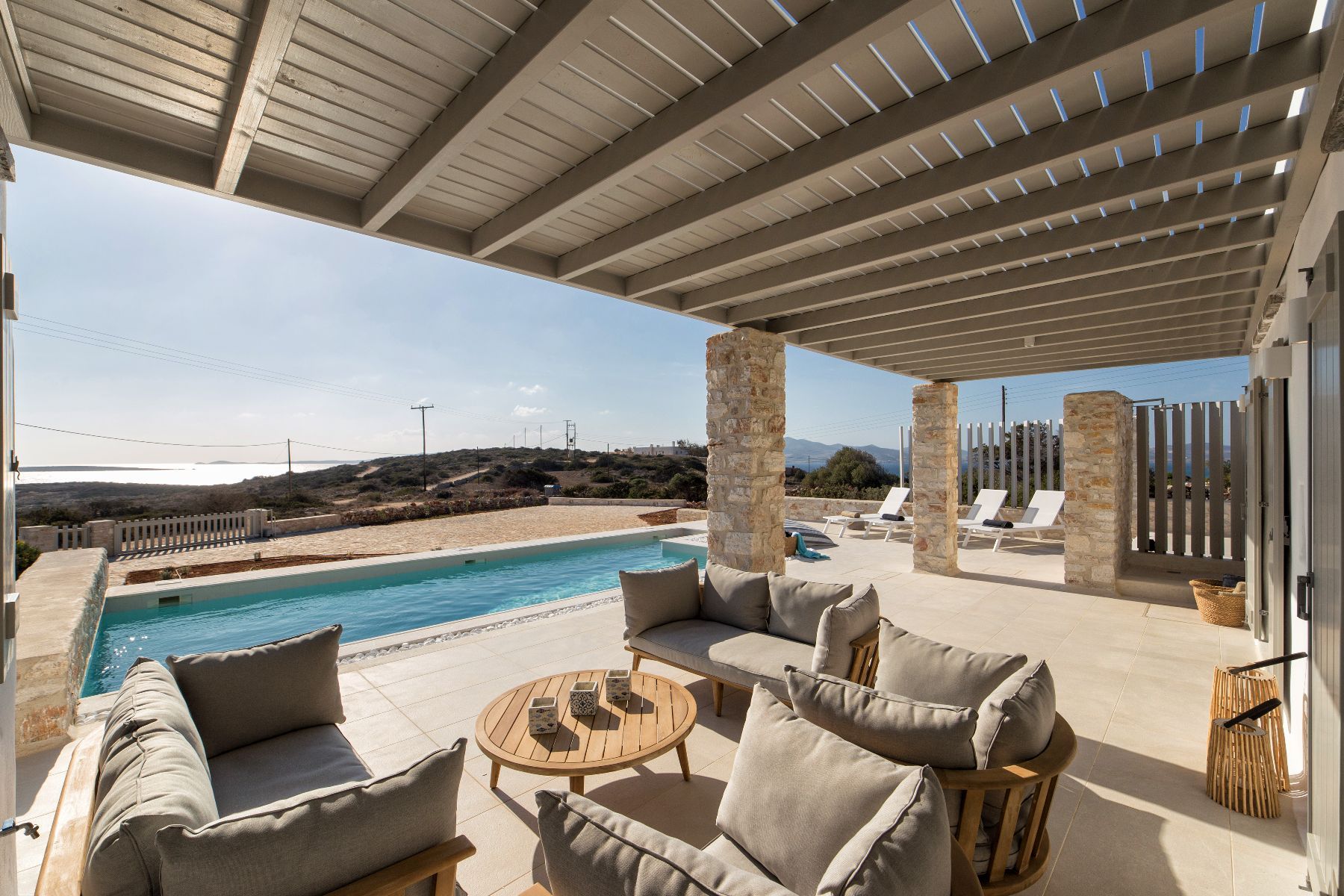 The pergola-shaded outdoor lounge provides a welcome sanctuary, a perfect vantage point for those sweeping sea views.