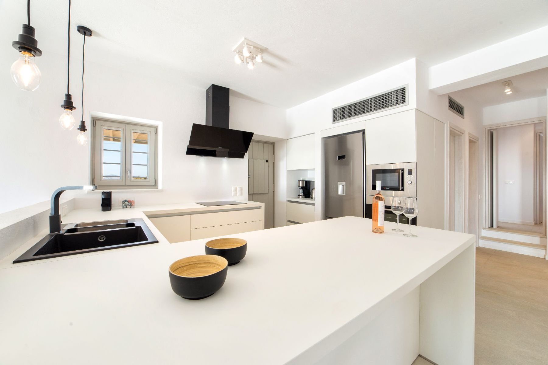 Modern and bright fully-equipped kitchen with stainless steel amenities and breakfast bar.