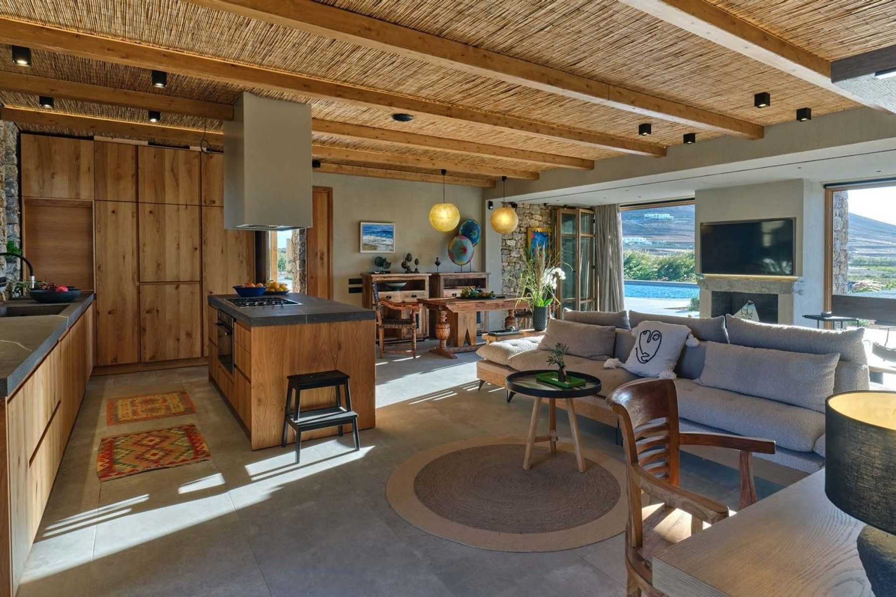 The interiors combine modern and traditional elements by using warm, earthy colors and natural materials like wood, stone, bamboo, and wicker.