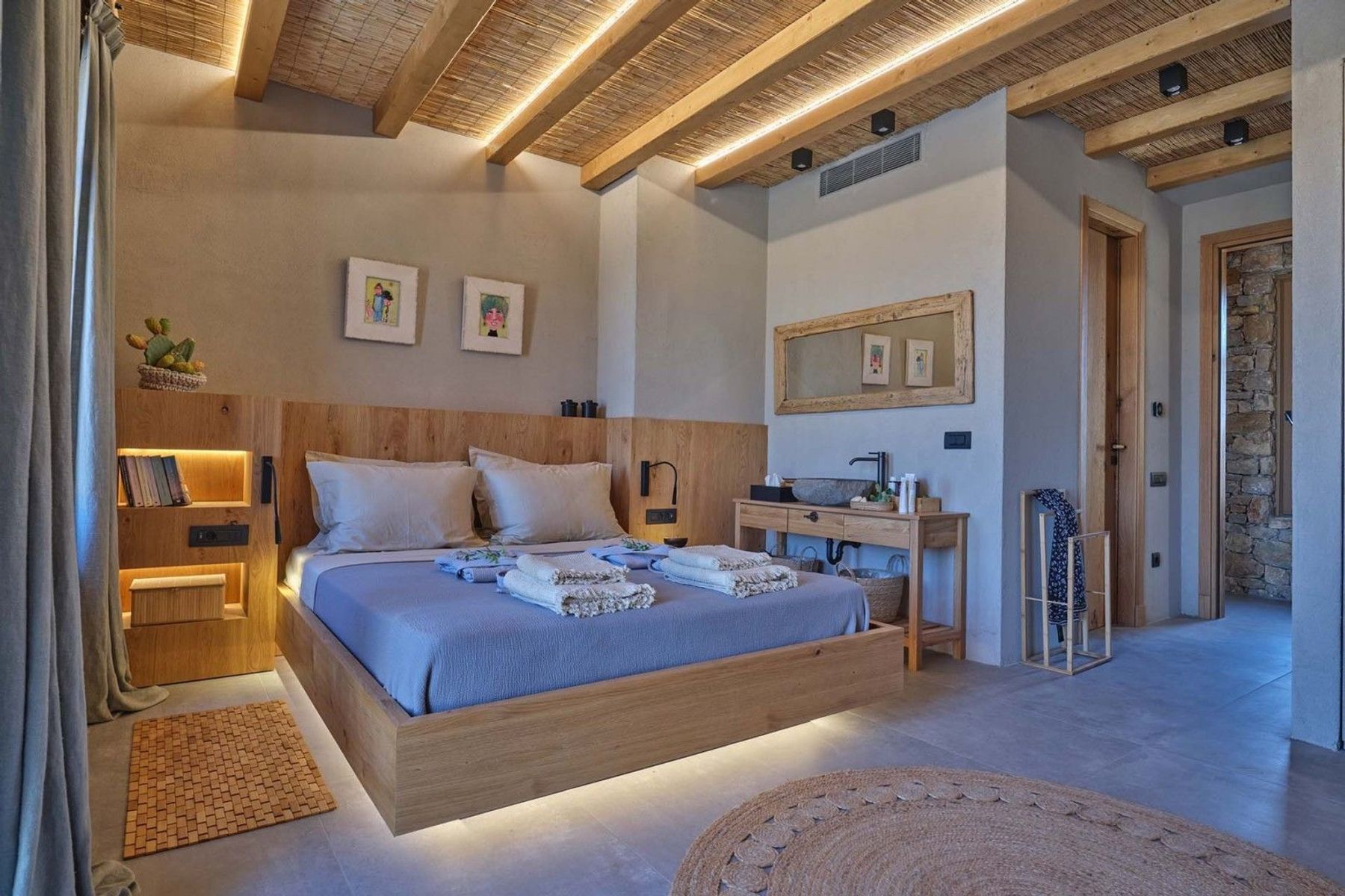 Modern ensuite bedroom with contemporary furnishings and plush bedding. There is also a separate wash basin and vanity unit.
