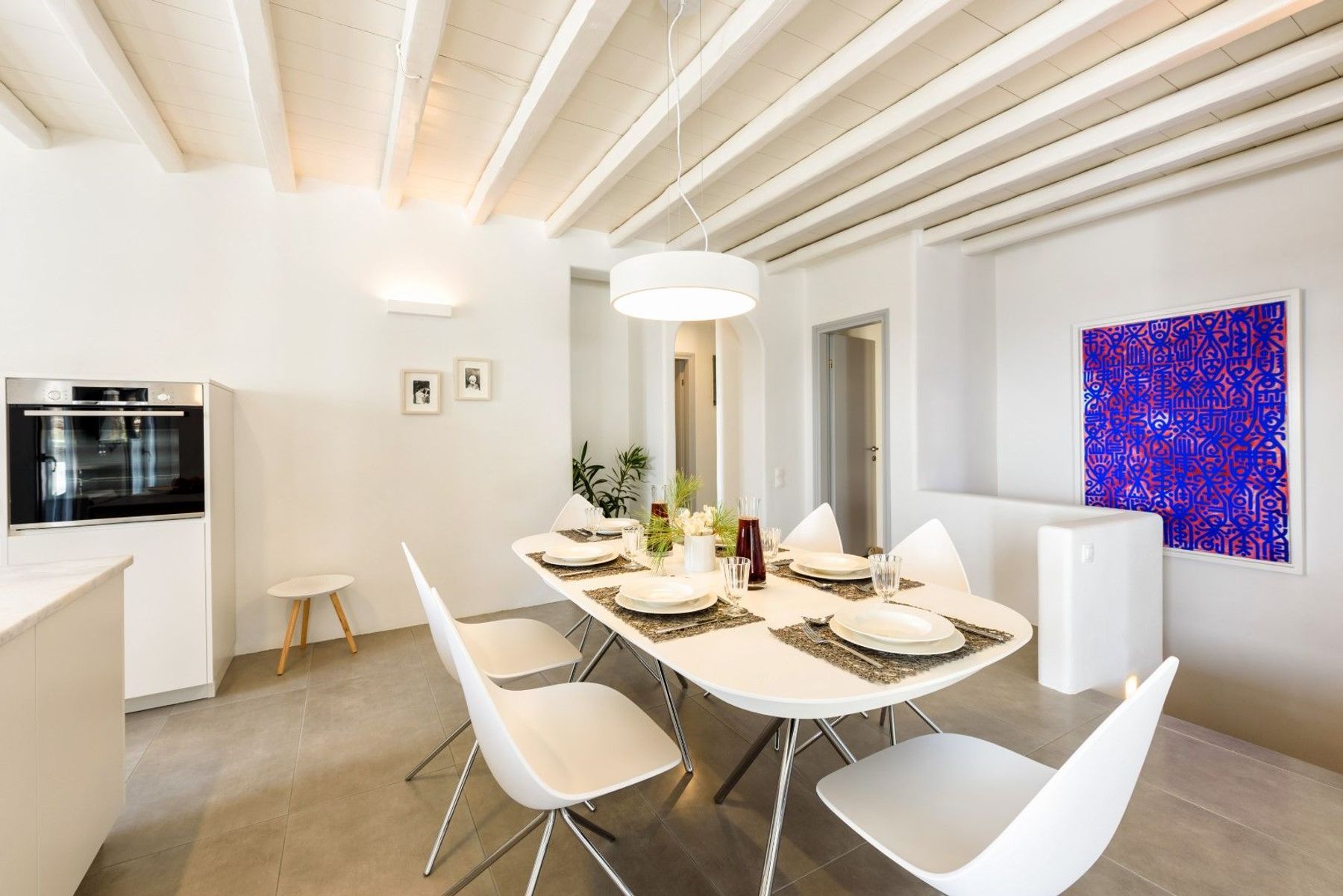 Open-plan kitchen with dining area, with a table seating six guests.