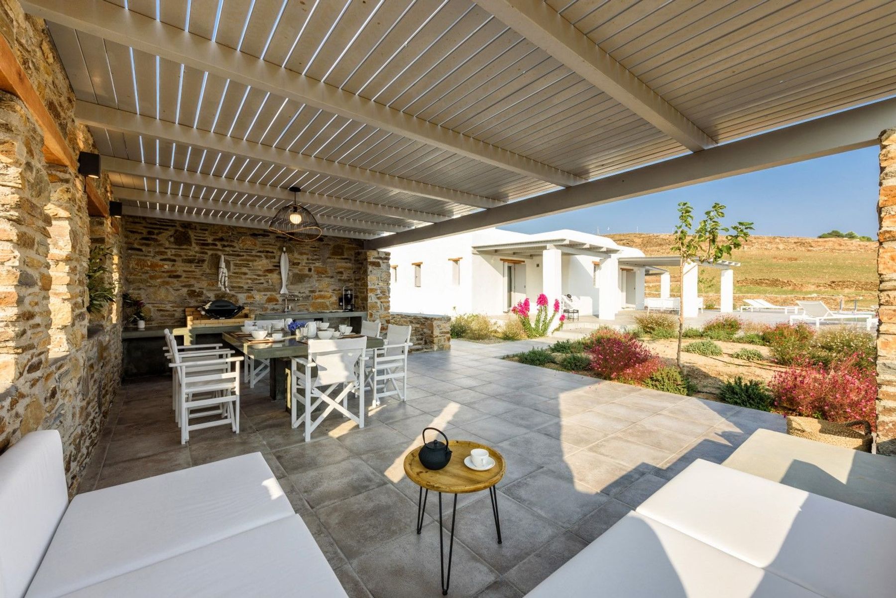 Pergola-covered dining and lounge area for alfresco dining with a view.