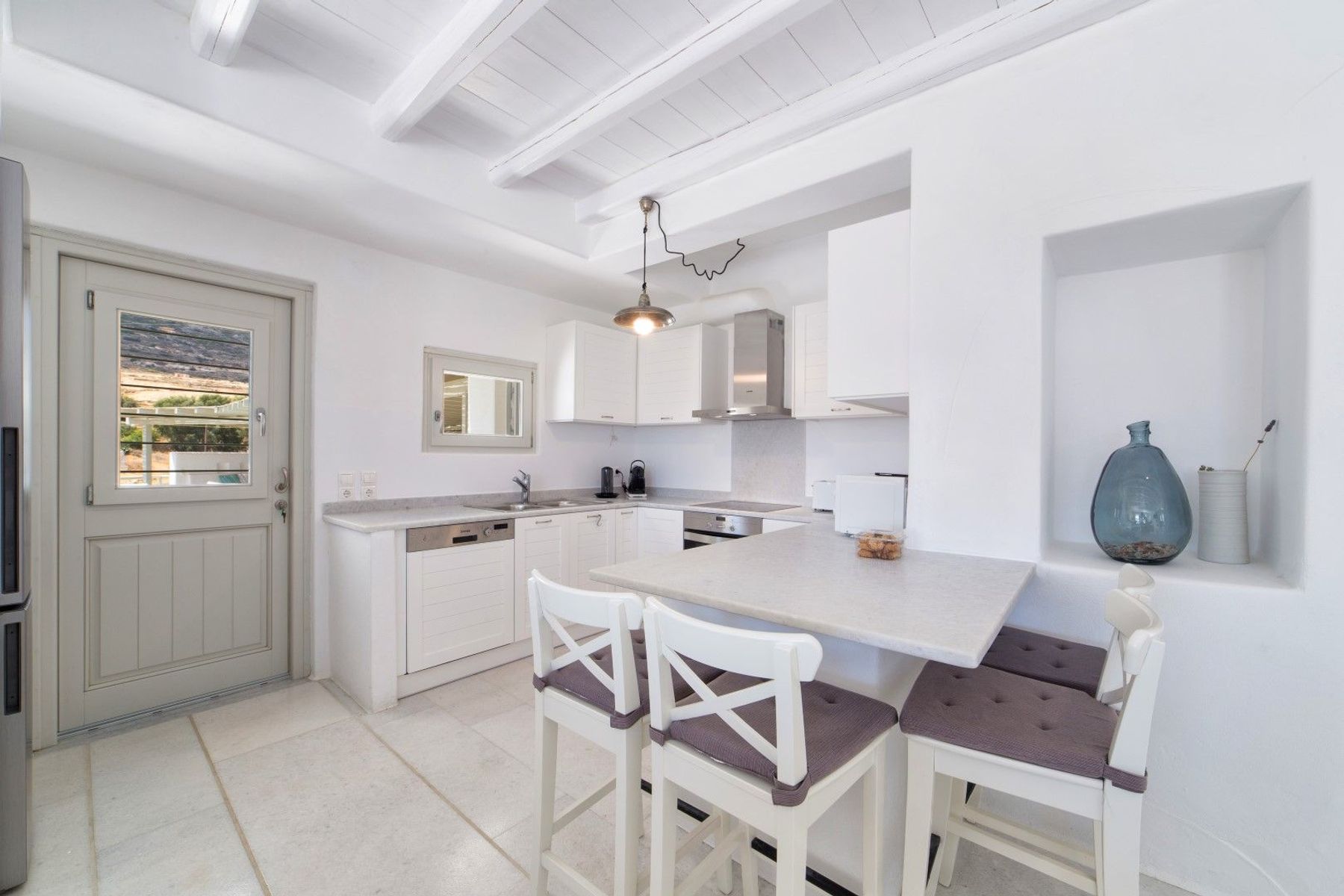 Modern kitchen with breakfast bar which seats four guests.