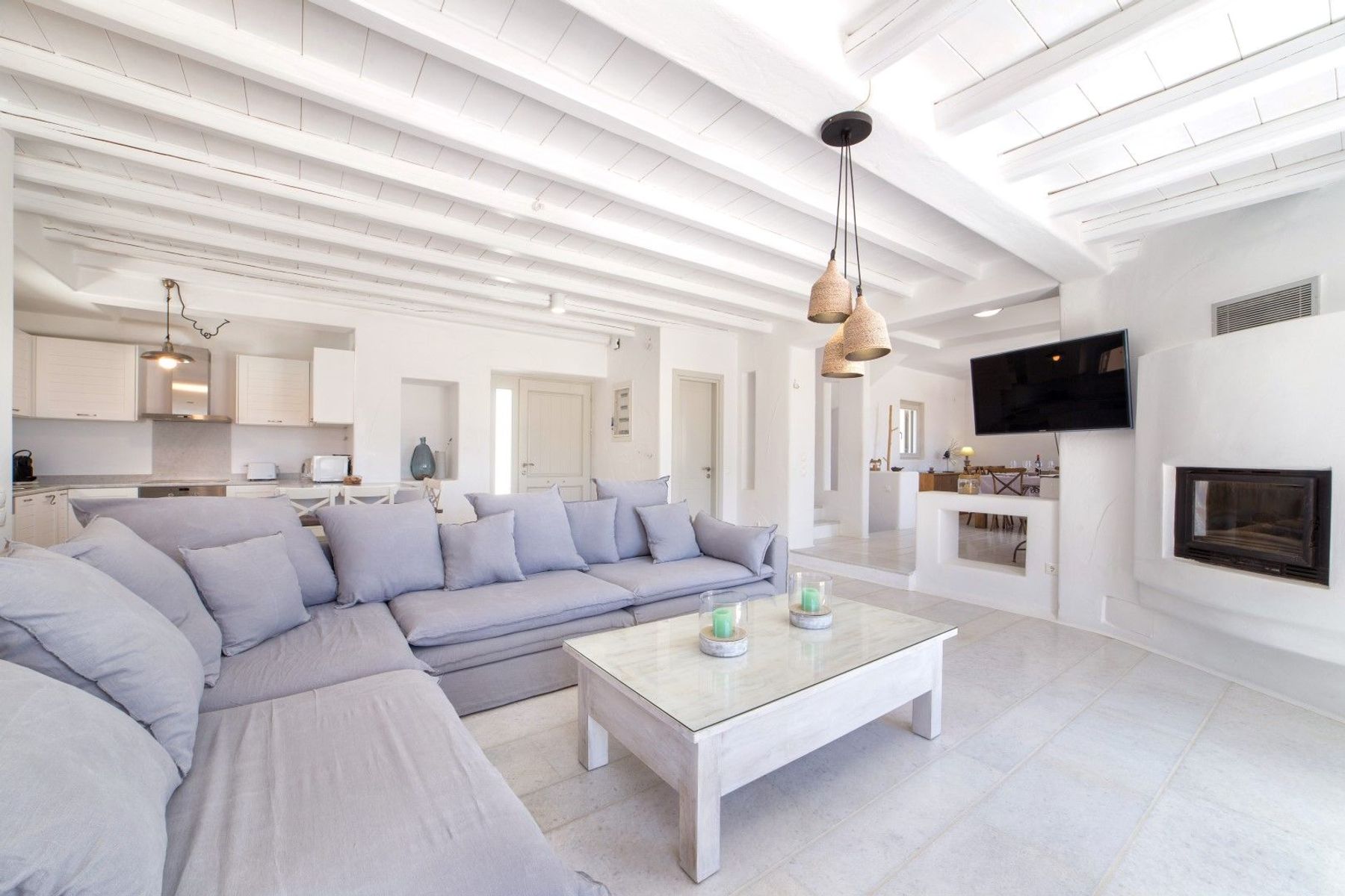 Bright main living room area features a television and a large inviting sofa.