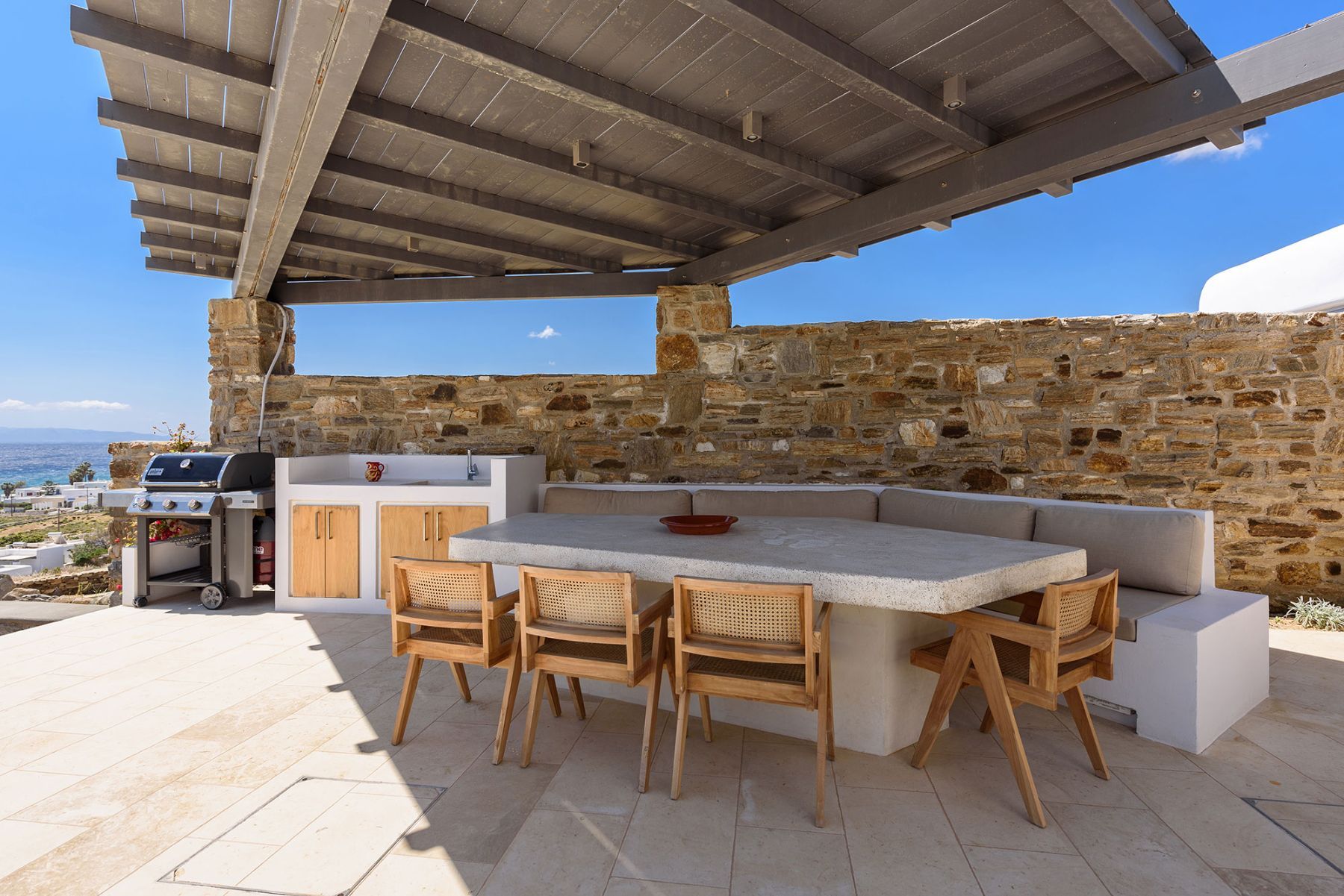 Dine together at the large stone-built table under the charming pergola shaded area.