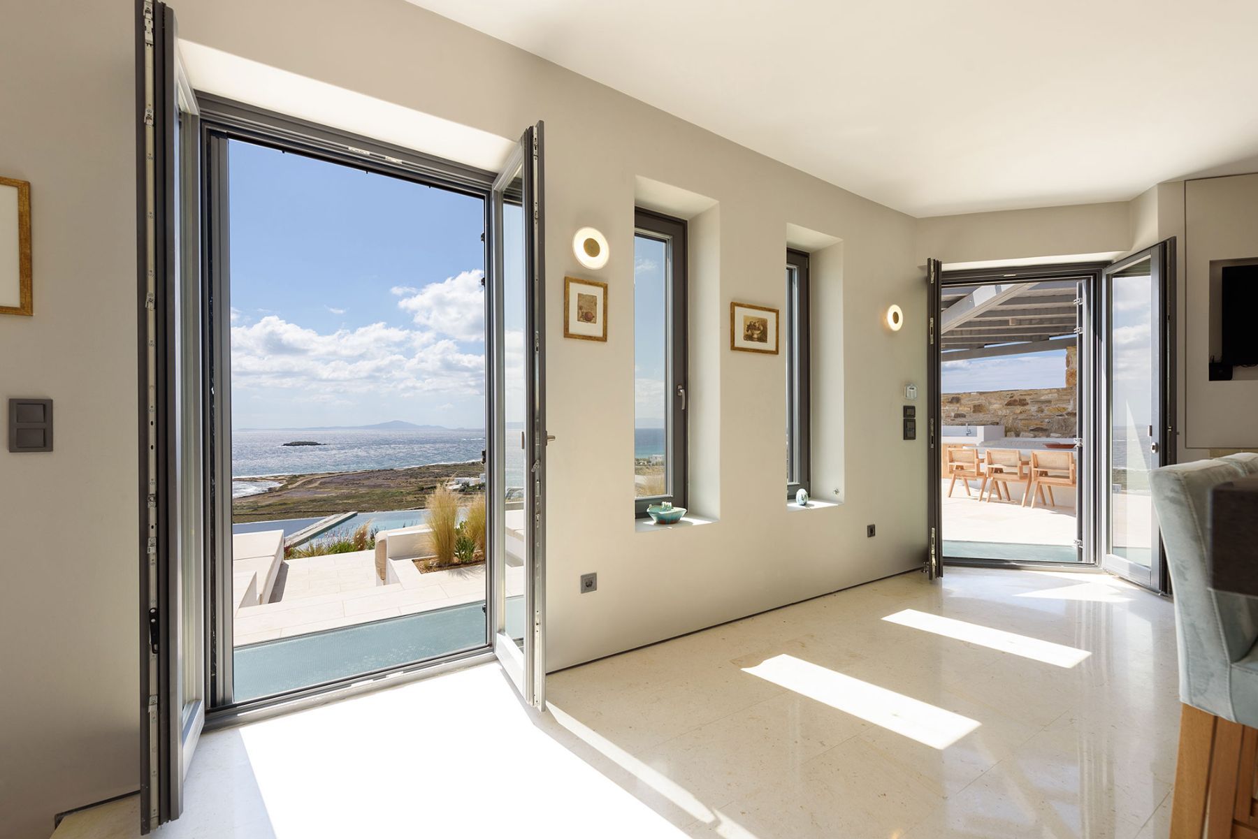 Floor-to-ceiling windows leading out to the terrace keeps the open-plan living space bright and airy.