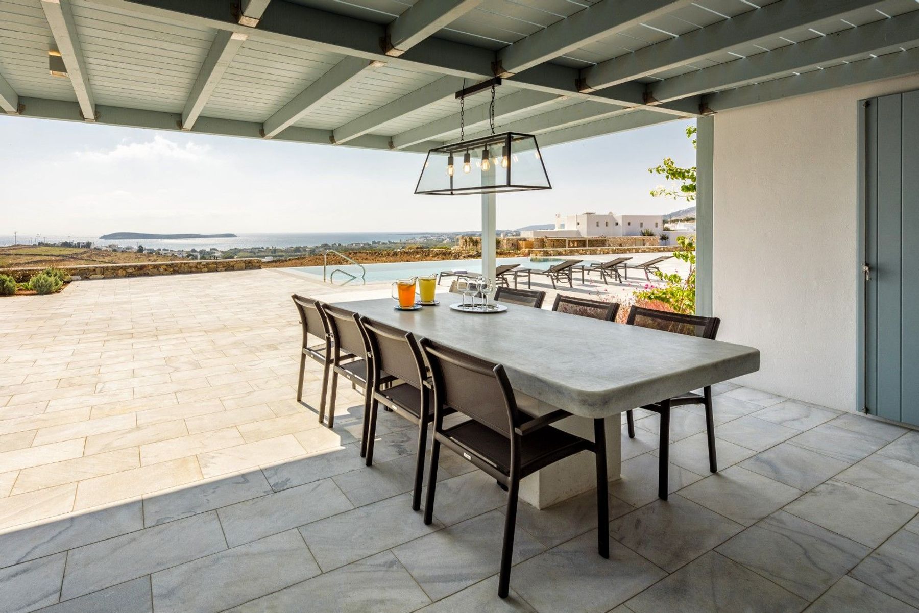 Shaded pergola-covered alfresco dining area, with a table seating eight guests.