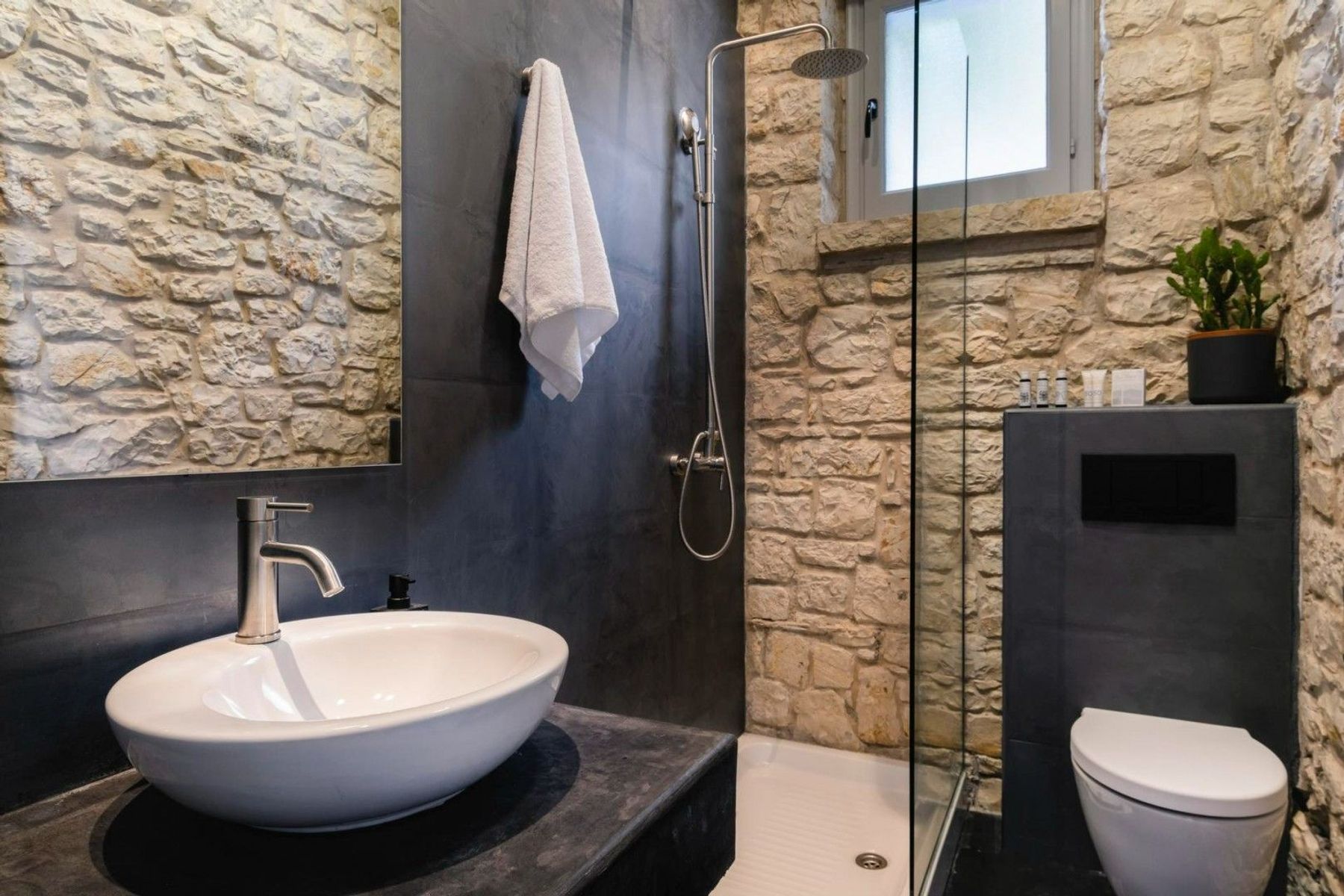 Contemporary spa-like bathroom with walk-in stone and charming stone brickwork. 