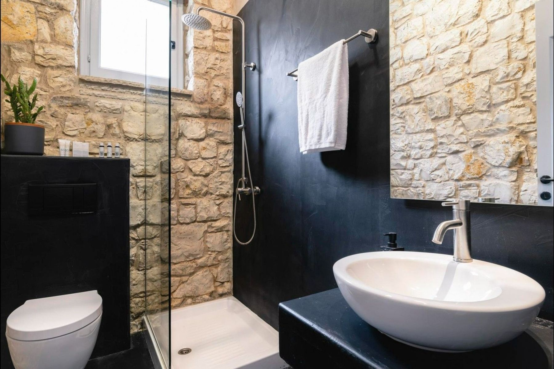 Modern spa-like ensuite bathroom with walk-in shower, WC and basin.