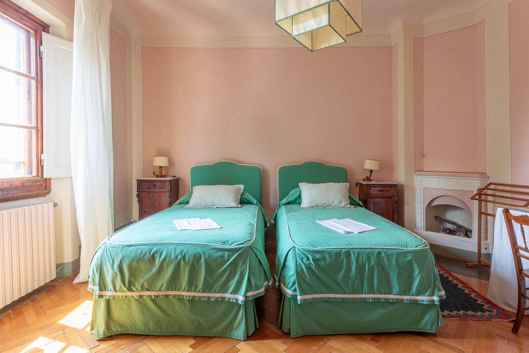 Twin bedroom with charming original features such as parquet flooring and fireplace.
