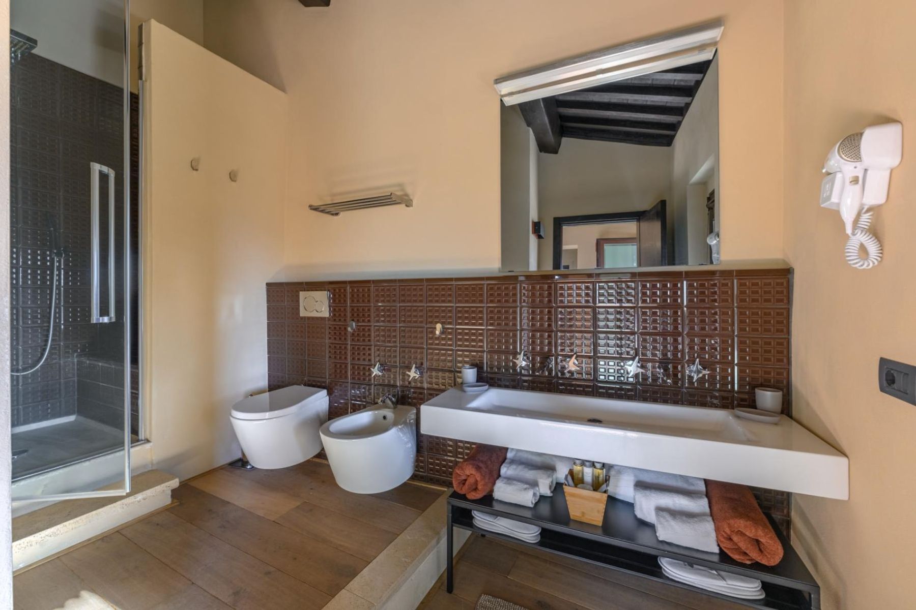 Modern ensuite bathroom with walk-in shower, double basin, bidet and hairdryer.