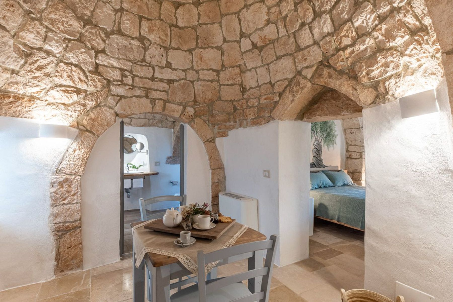 Queen-sized bedroom with air conditioning, smart TV, and charming seating area.