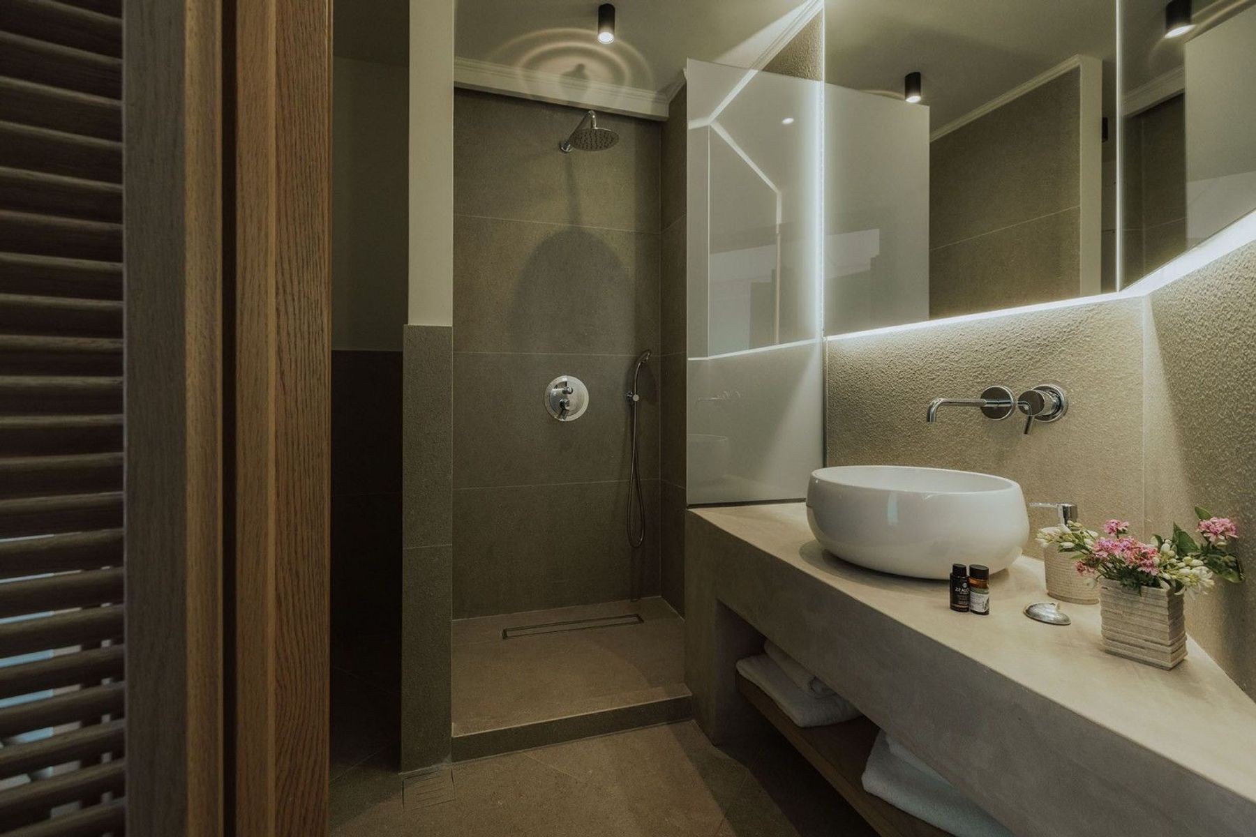 Spa-like ensuite bathroom with walk-in shower and modern basin with vanity unit. 