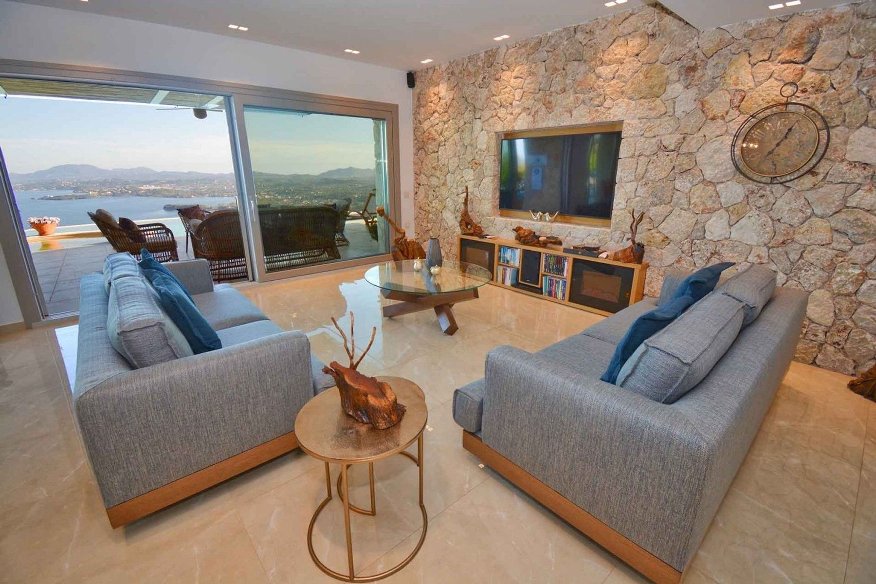 The modern living area features a television, home cinema sound system, and access to the pool terrace.