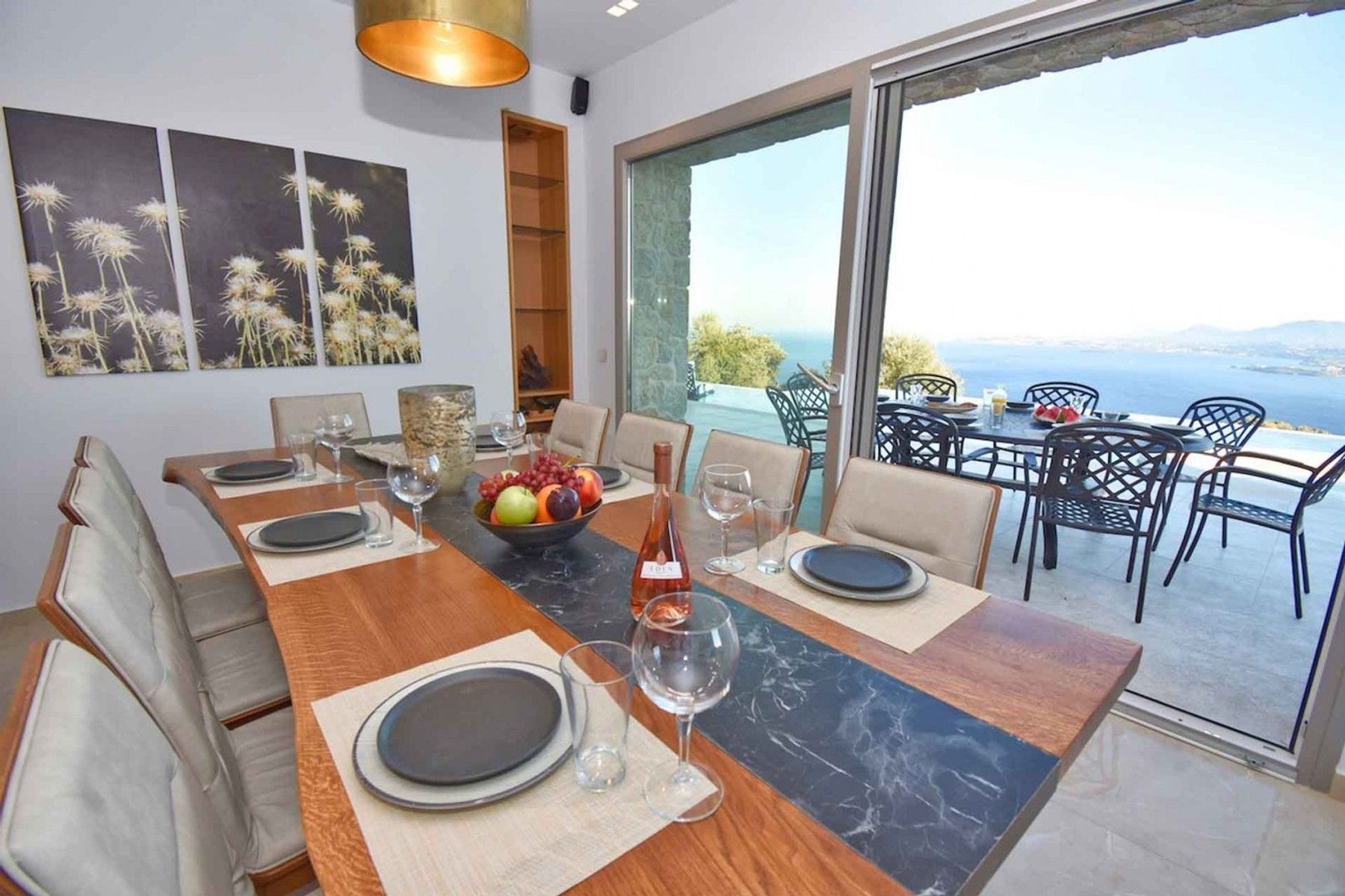 Modern dining area with space for up to twelve guests, and with super views of the pool and surrounding seascape. 