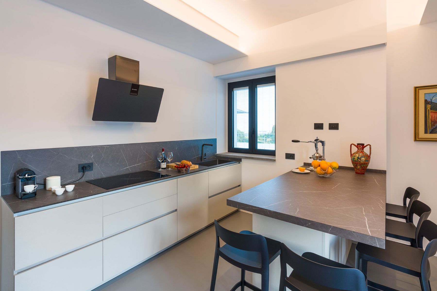 Modern fully-equipped kitchen with separate island, and seating for five people. 