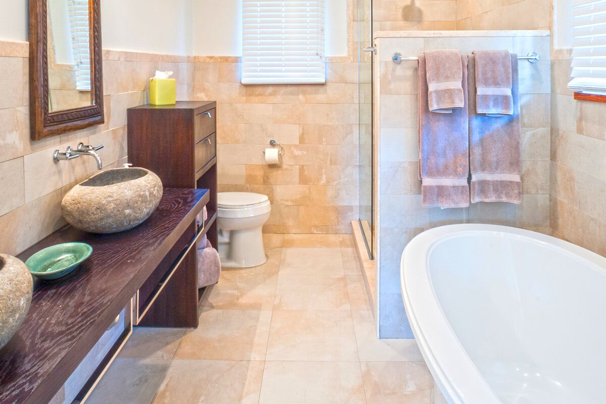 En suite bathroom with dual vanity and a bathtub 